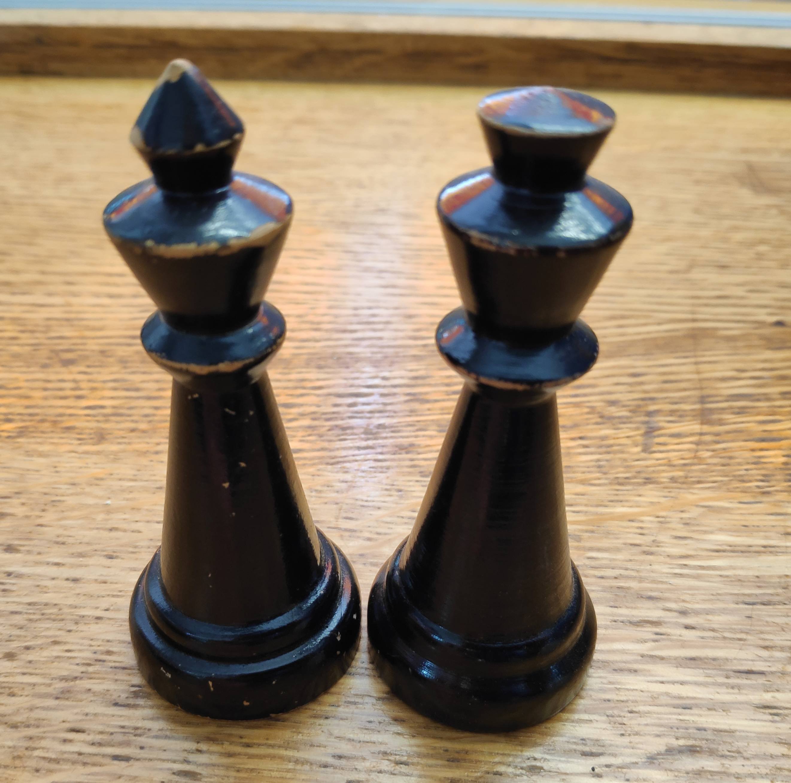 Chess pieces, one with a pointed crown on the left, and one with a rounded crown on the right